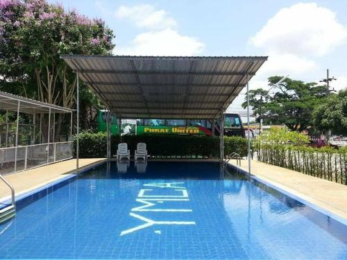 Ban Fang MinYMCA International Hotel Chiangrai的一个带两把椅子的游泳池