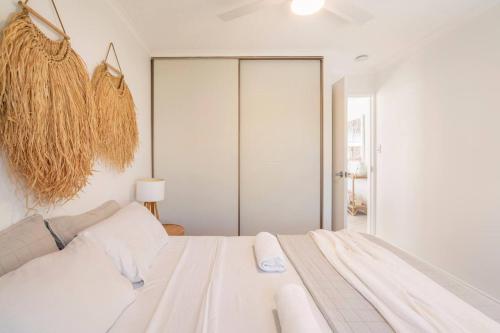玛志洛卡鲁阿度假公寓酒店的白色的卧室设有白色的床和窗户。