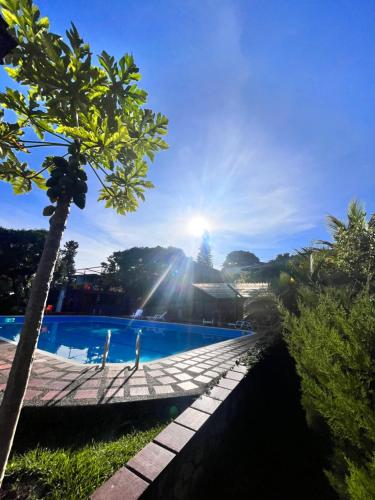 PapagallerosNatural Luxury Hotel的享有游泳池的景色,阳光在天空中