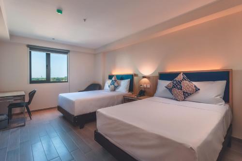 皮乌拉Lyz Business Hotel Piura的酒店客房配有两张床和一张书桌