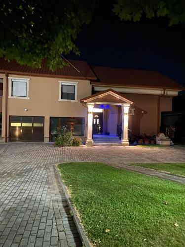 斯特鲁米察Villa Magnifica的夜间有照明车库的房子