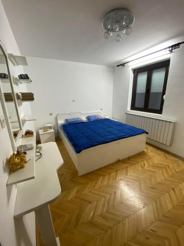 斯特鲁米察Villa Magnifica的一间卧室配有一张床,铺有木地板