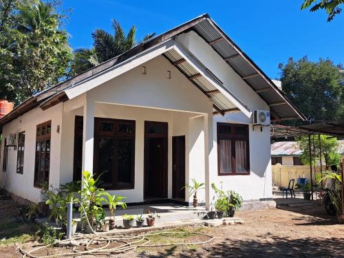 RiungRiung Tiga Empat Tujuh Guesthouse的前面有植物的小白色房子