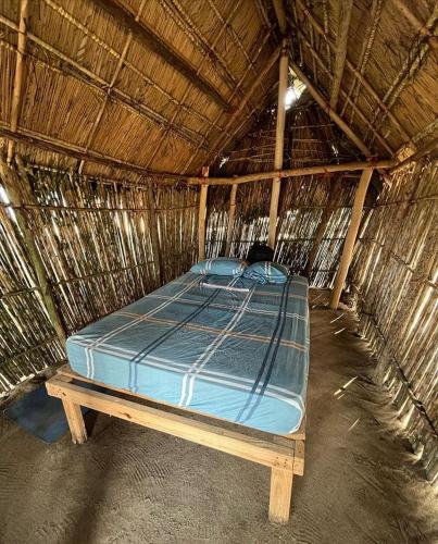 WarsobtuguaCabañas tradicionales en isla Aroma的一间稻草小屋内的一张床位