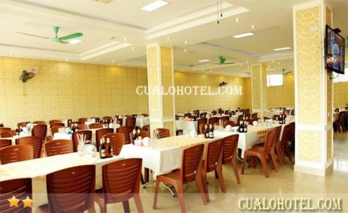 格卢市社Trường Sa Hotel Cửa Lò Beach的用餐室配有白色桌子和棕色椅子