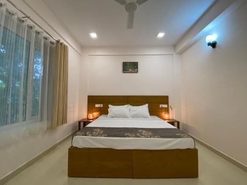 科钦Daffodils Luxury Airport Suites的一间卧室设有一张大床和一个窗户。