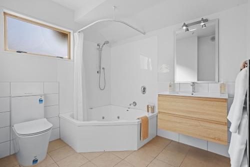 基督城洛伦佐汽车旅馆的带浴缸、卫生间和盥洗盆的浴室
