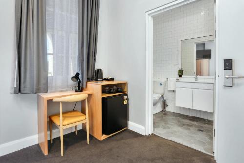 悉尼Penshurst Hotel的一间带书桌和卫生间的小厨房