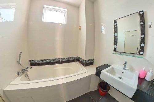 哥打丁宜Desaru Spacious 6 Rooms Bungalow 22paxes KTV-Billard-BBQ-Netflix的白色的浴室设有浴缸和水槽。
