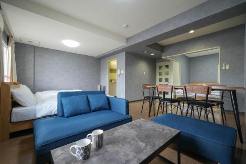 札幌Residence Hotel KABUTO的一间设有蓝色沙发、一张床和一张桌子的房间