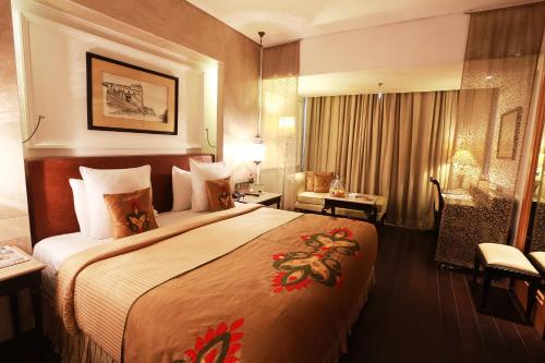 新德里新德里阿育王酒店的一间酒店客房,配有一张大床