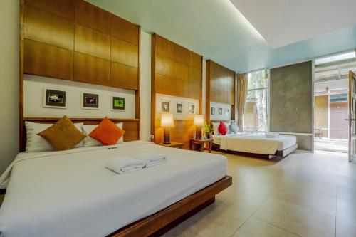 班康卡臣Nana Resort Kaeng Krachan - SHA Plus Certified的一间卧室设有两张床和大窗户