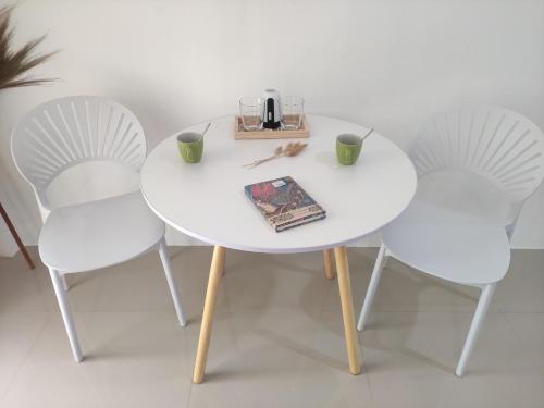 Ban Mo NaeLuana Villas的一张带两把椅子的白色桌子和一本书