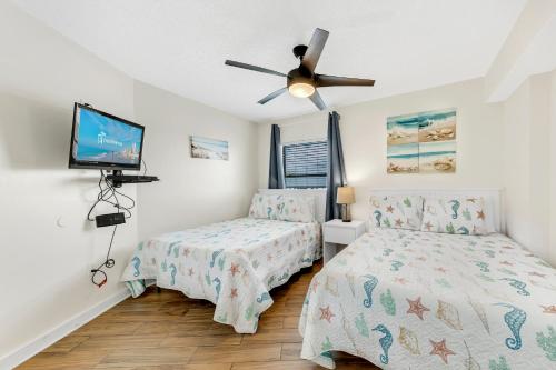 罗马尔海滩Seaside Beach & Racquet 5614的一间卧室配有两张床和吊扇