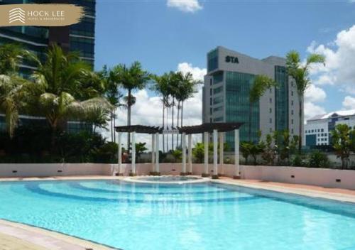古晋Hock Lee Hotel & Residences的一座棕榈树和建筑的大型游泳池