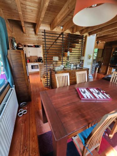 索姆勒兹Le chalet du Cerf - Chambres d'hôtes的一间带木桌的用餐室和一间厨房
