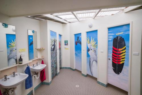 Church PointYHA Pittwater Eco, Sydney的浴室设有两个水槽,墙上设有冲浪板