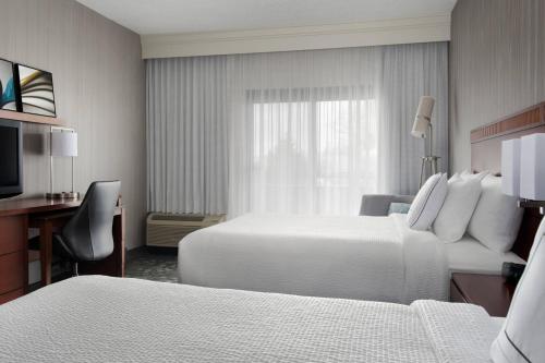 东叙拉古雪城环路万怡酒店的酒店客房配有两张床和一张书桌