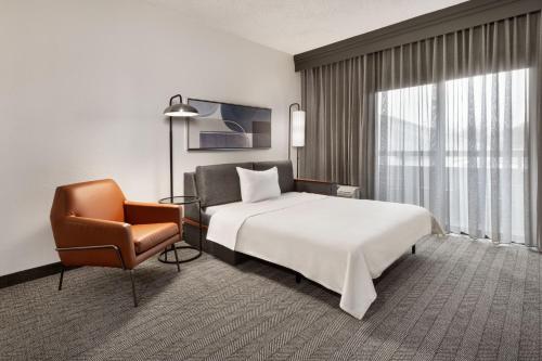 孟菲斯孟菲斯机场万怡酒店的配有一张床和一把椅子的酒店客房
