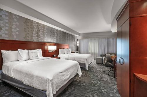 塔尔萨万豪图尔萨伍德兰山万怡酒店的酒店客房设有两张床和电视。