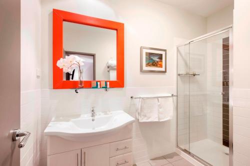 阿德莱德米勒公寓酒店的白色的浴室设有橙色镜子和水槽