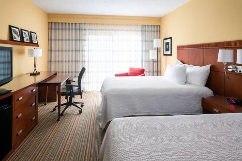 印第安纳波利斯Courtyard by Marriott Indianapolis Airport的酒店客房配有两张床和一张书桌