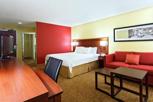 休斯顿休斯顿/布鲁克庭院酒店的酒店客房,设有床铺和红色的墙壁