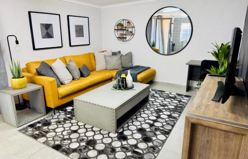 波罗瓜尼Lemon Ivy Guesthouse的客厅配有黄色沙发和镜子
