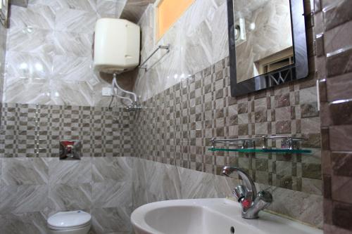 甘托克Dhe Kyi Khang by Magwave Hotels-100 Mts from MG Marg的一间带水槽、卫生间和镜子的浴室