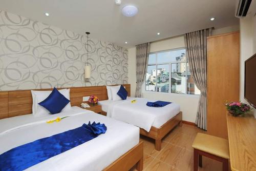 胡志明市Ailen Hotel的酒店客房设有两张床和电视。