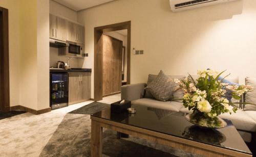 吉达Rasia Hotel Jeddah的客厅配有沙发和鲜花桌