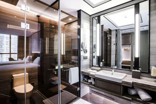 太原太原五洲假日酒店的一间带水槽和卫生间的浴室以及一张床