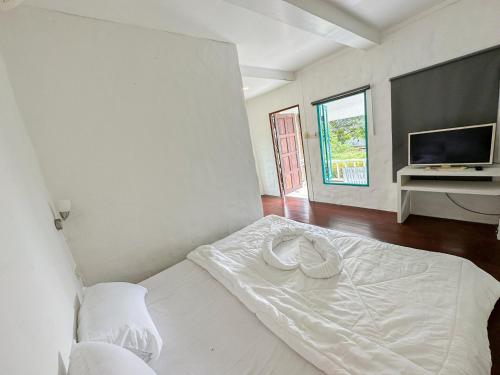 达叻府Capital O 75411 Navagio​ boutique​ Koh​ Chang​的卧室配有白色的床和电视。