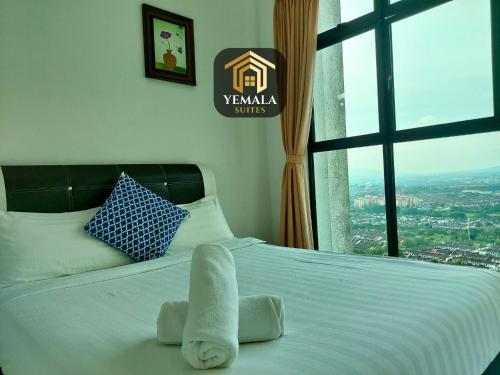 新山Yemala Suites at Skyloft - Johor的一张带毛巾的床,带窗户