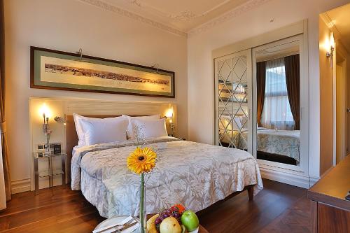 伊斯坦布尔塔克西姆特别类休息酒店的一间卧室,配有一张桌子上花的床铺
