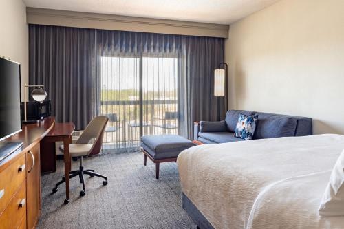 坦帕坦帕西岸万怡酒店/机场的酒店客房配有一张床、一张书桌和一台电视。