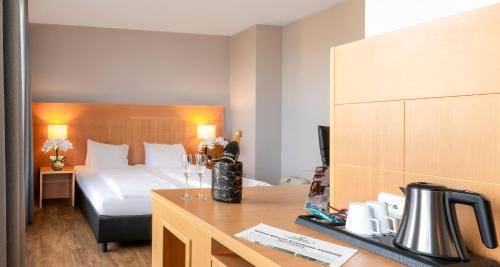 科隆PLAZA Premium Köln的配有一张床和一张书桌的酒店客房