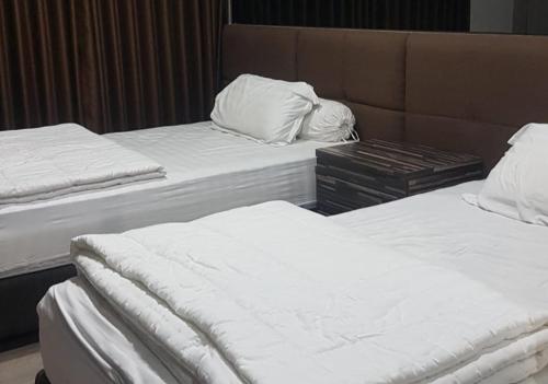 Beran-kidulApartemen Patraland Amarta Yogyakarta Jogja AC dan Air Panas的客房内的两张床和白色床单