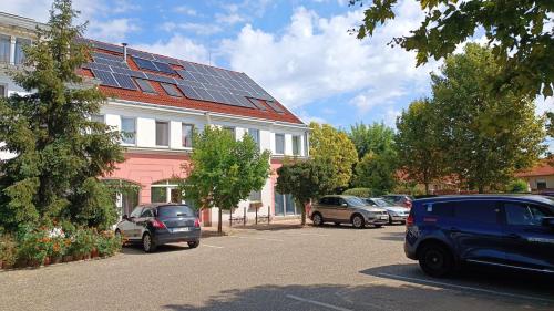 德布勒森普兰滕酒店的停车场的停车场位于一栋带太阳能电池板的大楼前。