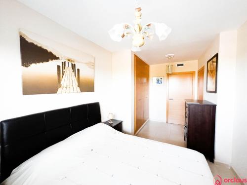 奥罗佩萨德尔马La Terrace的卧室配有白色的床和吊灯。