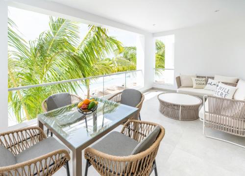 拉古纳Aqua Esmeralda Luxury Beach Front Apartment的阳台配有桌椅和沙发。