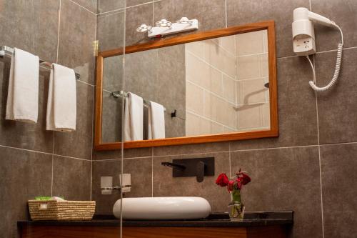 阿鲁沙Forest Hill Hotel的一间带水槽和镜子的浴室