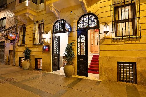 伊斯坦布尔塔克西姆特别类休息酒店的一座带黑色门和两扇窗户的建筑