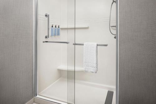 印第安纳波利斯印第安纳波利斯西北酒店的浴室里设有玻璃门淋浴