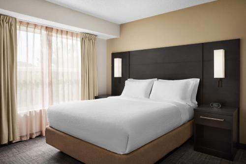 印第安纳波利斯印第安纳波利斯西北酒店的一间卧室设有一张大床和一个大窗户
