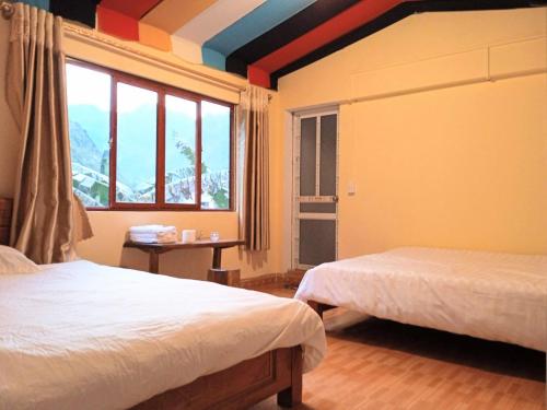 Mèo VạcA Kiệt Homestay的一间卧室设有两张床和彩虹天花板