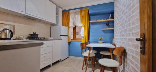Samtrediarelax的厨房设有蓝色墙和小桌子。