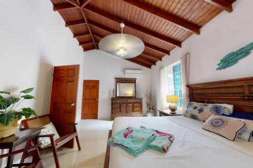 基督教堂市Kismet Garden Cottages - Dover Beach的卧室配有一张白色大床和木制天花板