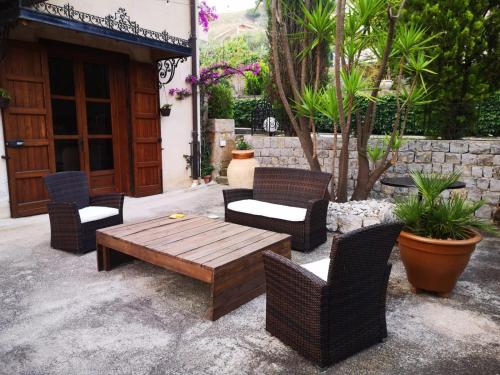 MontelepreVilla Calcerame的庭院设有藤椅和木桌