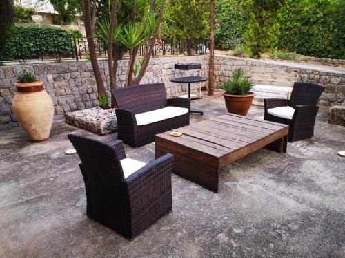 MontelepreVilla Calcerame的庭院配有椅子、木桌和桌椅